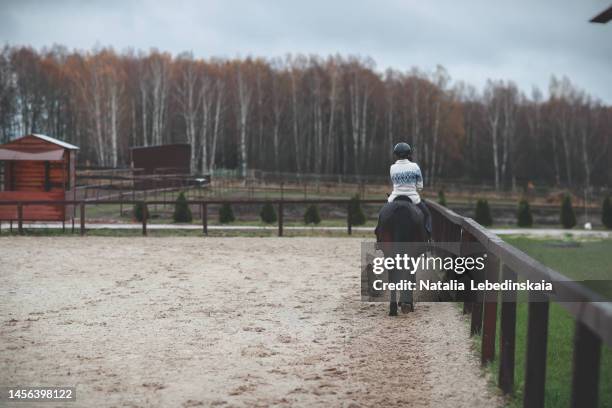 teenager girl with disabilities riding horse in autumn. back view. - animal head human body stock pictures, royalty-free photos & images