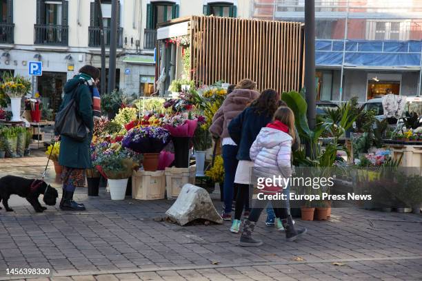 Woman buys flowers at a stall in Tirso de Molina square, on 14 January, 2023 in Madrid, Spain. On January 14 in Madrid . The Tirso de Molina Flower...