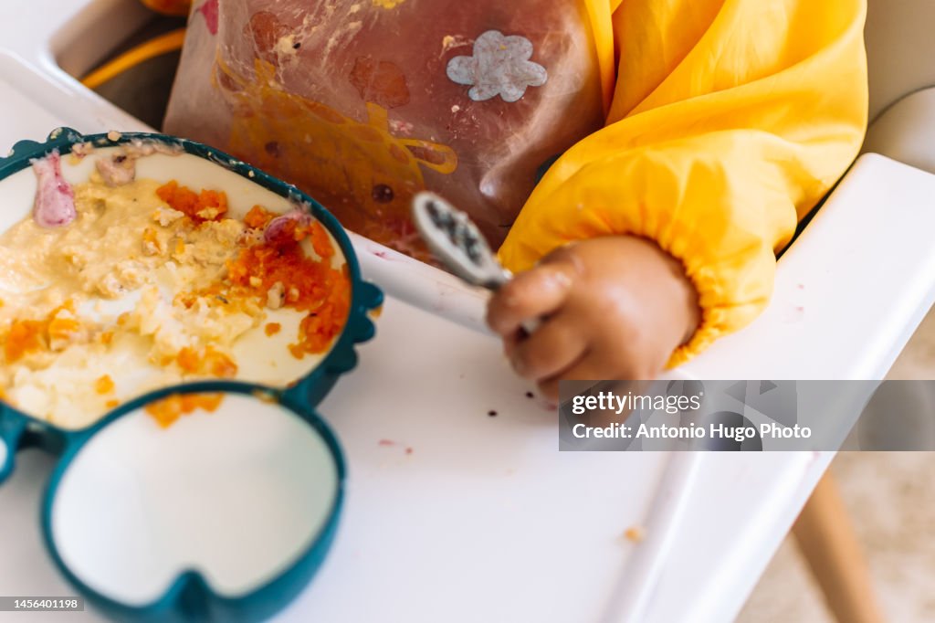 Cute baby learning to eat with a spoon. Baby lead weaning method.