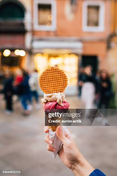 sosteniendo helado orgánico de sabor a fresa y caramelo - gelato fotografías e imágenes de stock