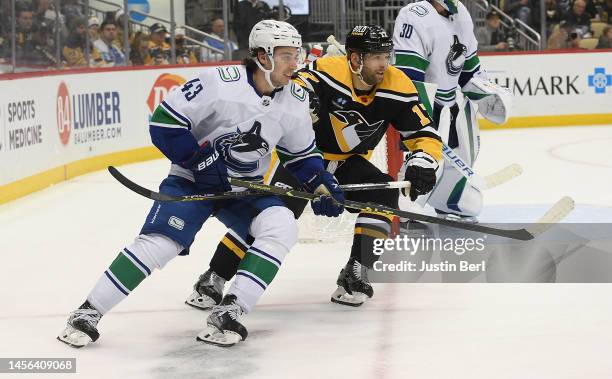 Quinn Hughes of the Vancouver Canucks skates against Bryan Rust of the Pittsburgh Penguins in the third period during the game at PPG PAINTS Arena on...
