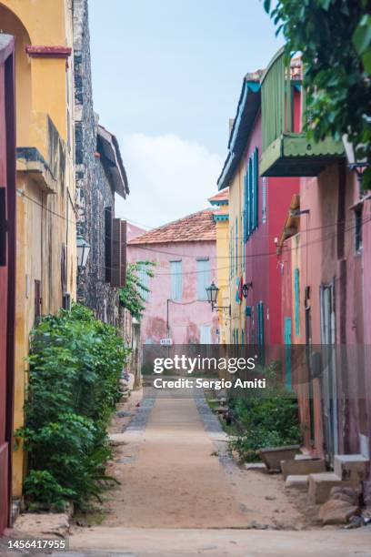 narrow street with colonial buildings on gorée island - dakar stockfoto's en -beelden