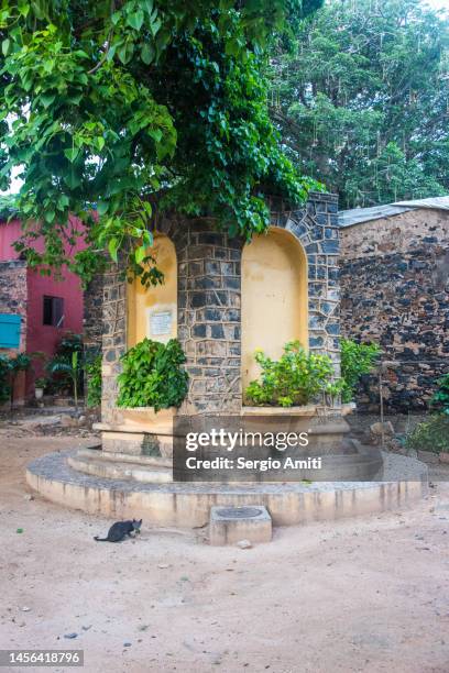 cat by memorial fountain - senegal monument stock pictures, royalty-free photos & images