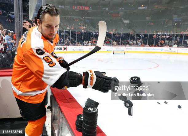 Ivan Provorov of the Philadelphia Flyers dumps the pucks to the ice surface for warm-ups prior to his game against the Toronto Maple Leafs at the...