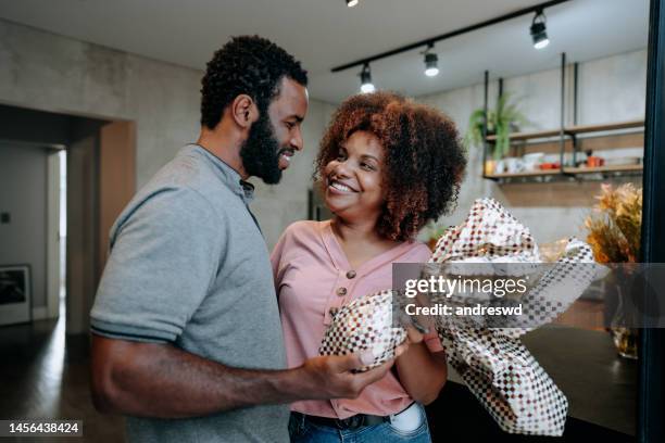 husband gives easter egg to wife - african easter stock pictures, royalty-free photos & images