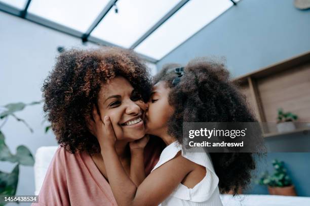 mother and daughter mothers day - mother and daughter kissing stock pictures, royalty-free photos & images
