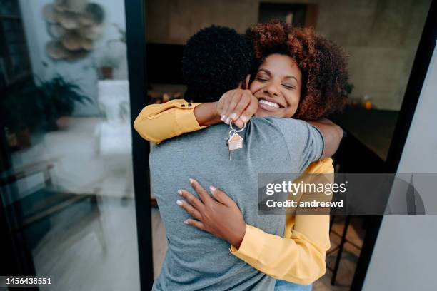 ecstatic couple holding keys to new home - moving house stock pictures, royalty-free photos & images
