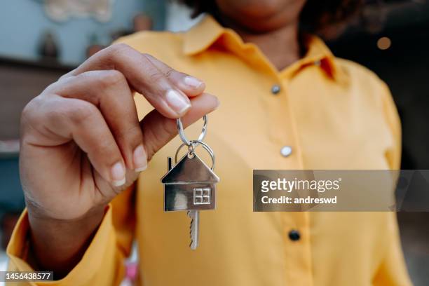 makler hält hausschlüssel - house keys stock-fotos und bilder
