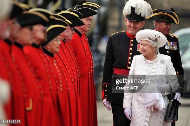 Britain's Queen Elizabeth II is greeted by Chelsea pensioners at Chelsea Pier in London on June 3, 2012 at the start of the Thames Diamond Jubilee...