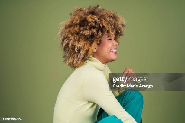 studioaufnahme einer attraktiven jungen frau, die vor grünem hintergrund aufgeregt aussieht - funky hair studio shot stock-fotos und bilder