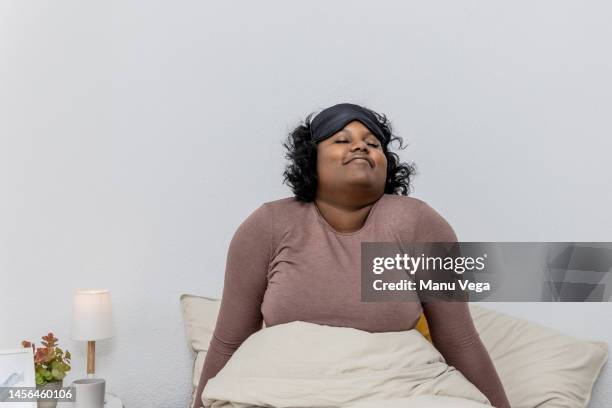 woman waking up in her bed at home. - duvet stock pictures, royalty-free photos & images