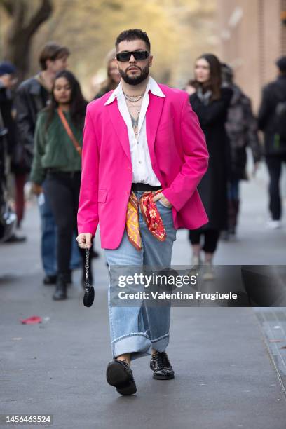 Guest is seen wearing a pink blazer jacket over a long collar button shirt, necklaces, denim pants and a foulard-belt outside the Fendi show during...