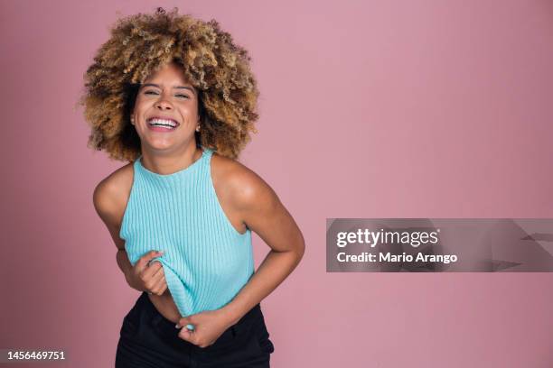 studioaufnahme einer attraktiven jungen frau, die vor einem rosa hintergrund aufgeregt aussieht - funky hair studio shot stock-fotos und bilder