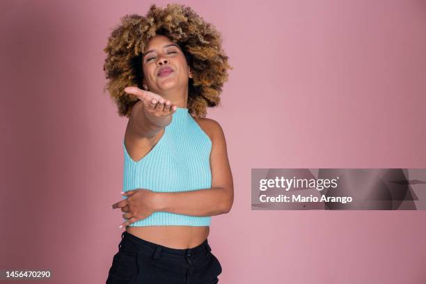 studioaufnahme einer attraktiven jungen frau, die vor einem rosa hintergrund aufgeregt aussieht - funky hair studio shot stock-fotos und bilder