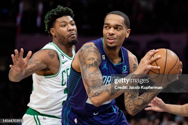Washington of the Charlotte Hornets looks to pass while guarded by Marcus Smart of the Boston Celtics in the first quarter during their game at...