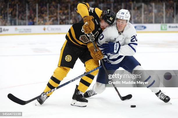 Tomas Nosek of the Boston Bruins and Dryden Hunt of the Toronto Maple Leafs battle for control of the puck during the first period at TD Garden on...