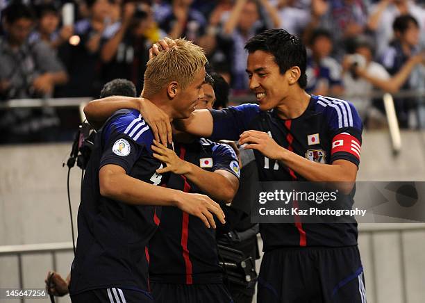 Keisuke Honda of Japan celebrates scoring the first goal with his teammate Yuto Nagatomo and Makoto Hasebe during the FIFA World Cup Brazil Asian...