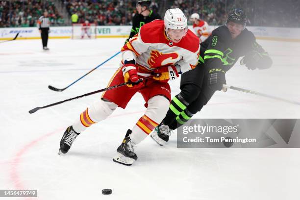 Walker Duehr of the Calgary Flames controls the puck against Miro Heiskanen of the Dallas Star in the second period at American Airlines Center on...