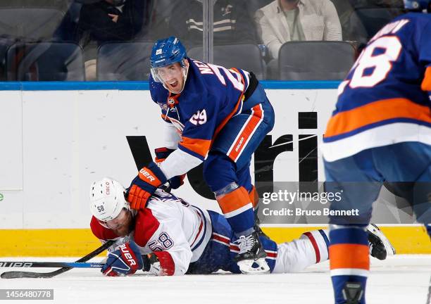 Brock Nelson of the New York Islanders gets tangled with David Savard of the Montreal Canadiens during the third period at the UBS Arena on January...