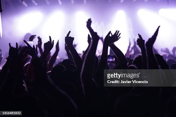human hands against a lit background. - concert hands stock pictures, royalty-free photos & images