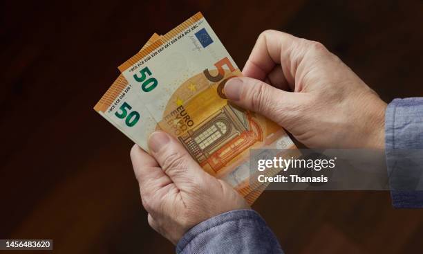 close-up of man's hand holding and counting money, european union currency - euro schein stock-fotos und bilder