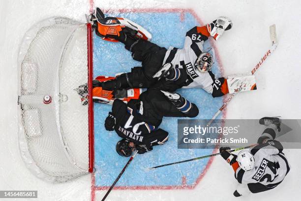 Garnet Hathaway of the Washington Capitals collides with goalie Carter Hart of the Philadelphia Flyers during the third period at Capital One Arena...