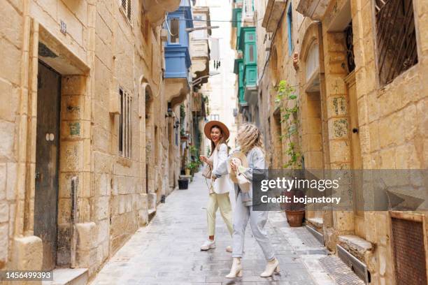 happy travelers in old mediterranean town - malta city stock pictures, royalty-free photos & images