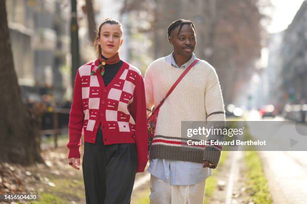 Guest wears a red with green monogram print pattern silk scarf from Kenzo, a black turtleneck pullover, a red and pale pink checkered print pattern...