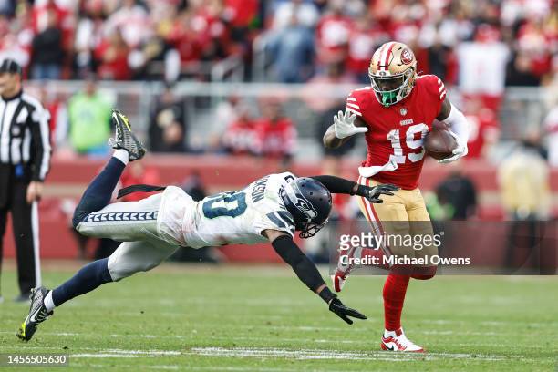 Deebo Samuel of the San Francisco 49ers runs with the ball as Mike Jackson of the Seattle Seahawks attempts to make the tackle during an NFL football...
