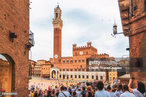wide angle view of famous torre del mangia at palazzo pubblico in siena, italy - torre del mangia stock pictures, royalty-free photos & images