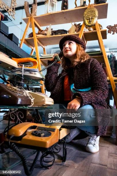 a woman goes shopping in an antique shop - antique shop stock pictures, royalty-free photos & images