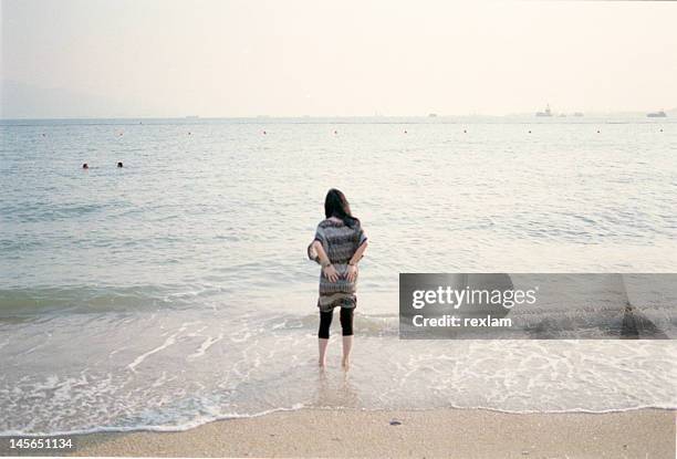 rear view of woman standing in sea - tuen mun stock pictures, royalty-free photos & images