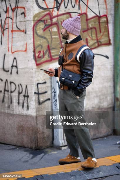 Guest wears a pale burgundy wool beanie, a beige wool turtleneck pullover, a camel felt with black shiny leather sleeves teddy jacket from Louis...