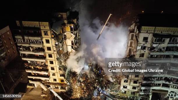 An aerial view of firefighters conducting search and rescue operations at residential building hit by a missile on January 15, 2023 in Dnipro,...