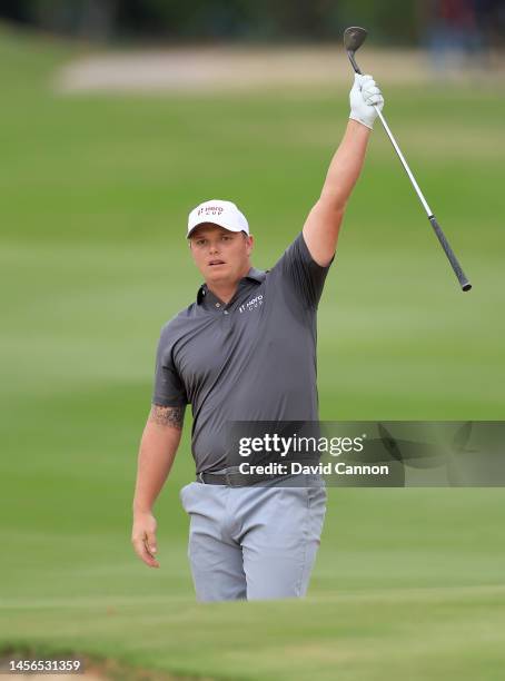 Callum Shinkwin of England and the Great Britain and Ireland Team celebrates holing from a green-side bunker for an eagle on the second hole during...