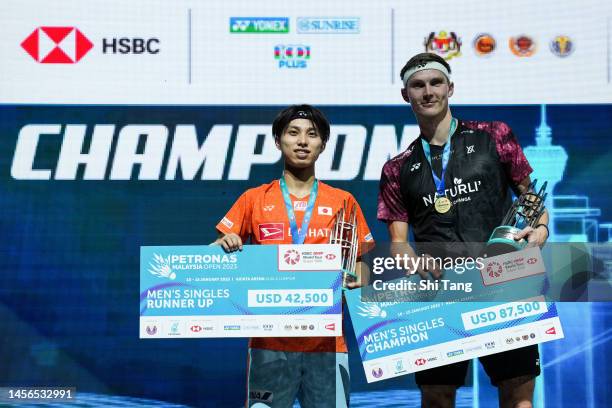 Viktor Axelsen of Denmark and Kodai Naraoka of Japan pose with their medals on the podium after the Men's Single Final match on day six of PETRONAS...