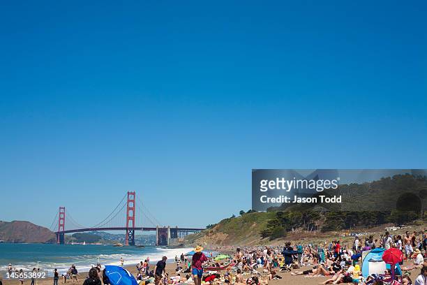 crowds at baker beach with golden gate bridge - baker beach stock pictures, royalty-free photos & images