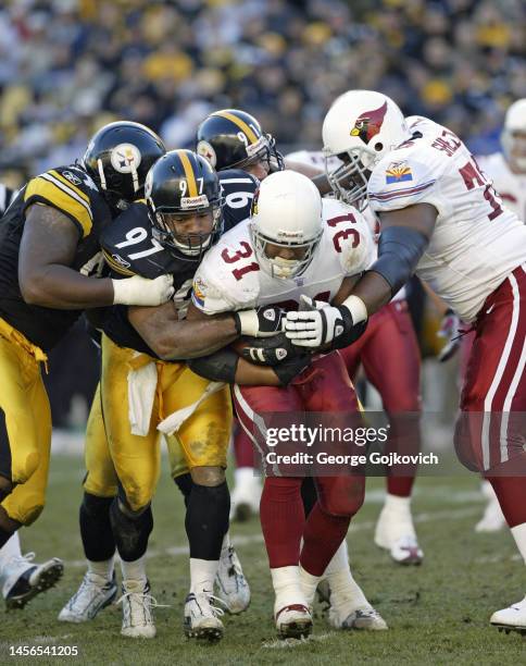 Linebacker Kendrell Bell of the Pittsburgh Steelers tackles running back Marcel Shipp of the Arizona Cardinals as defensive linemen Rodney Bailey and...