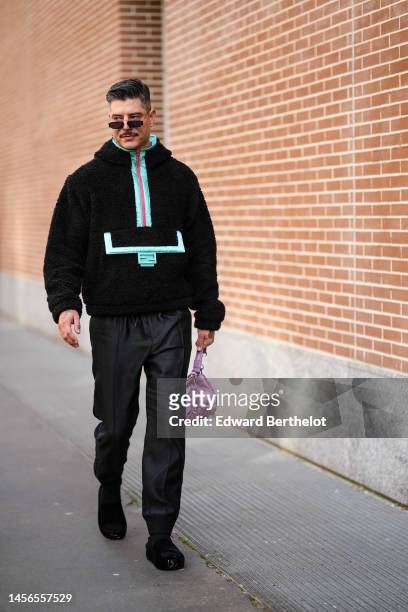 Guest wears black sunglasses, a black fluffy with flashy blue details zipper high neck sweater from Fendi, black suit pants, a pale purple nylon...