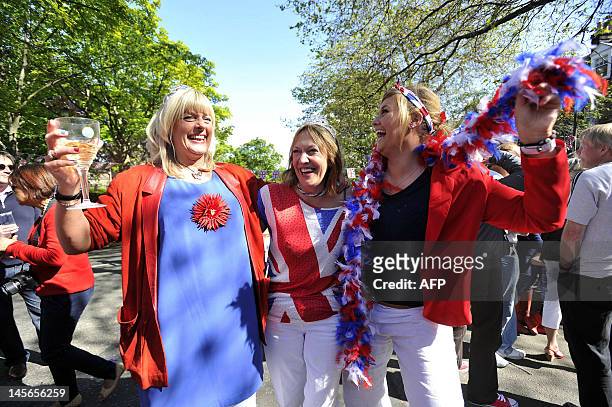 Revellers cheer with Britain's Union flags during a street party to celebrate the Queen's Diamond Jubilee in Edinburgh on June 3, 2012. Britain is...