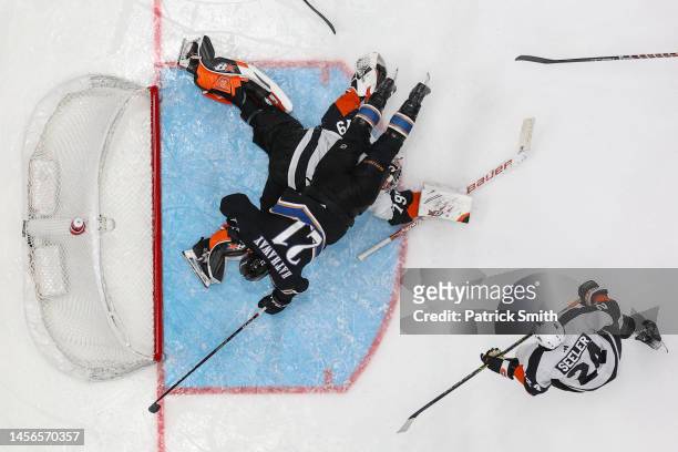 Garnet Hathaway of the Washington Capitals collides with goalie Carter Hart of the Philadelphia Flyers during the third period at Capital One Arena...