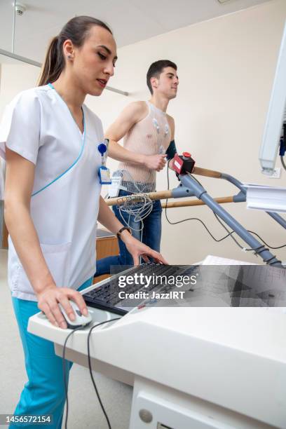 nurse is doing test to young male patient - cardiologist stock pictures, royalty-free photos & images