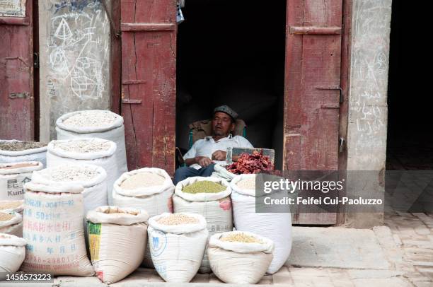 a market vendor uyghur man sleeping  at old town kashgar - ouïgour photos et images de collection