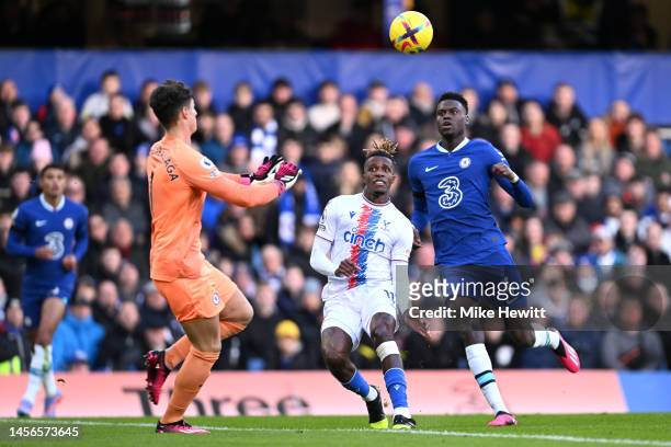 Kepa Arrizabalaga of Chelsea controls the ball as Wilfried Zaha of Crystal Palace looks on during the Premier League match between Chelsea FC and...