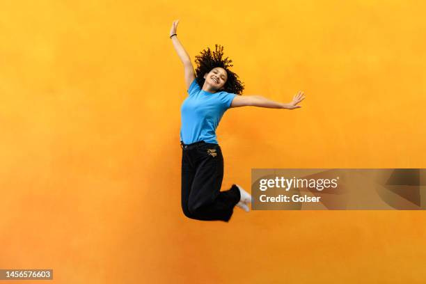 young woman jumping high in joy - flowers royalty free stock pictures, royalty-free photos & images