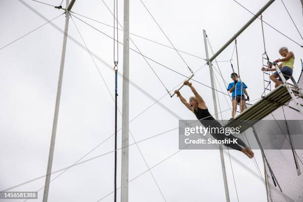mature trapeze artist started flying - trapezeartiest stockfoto's en -beelden