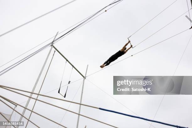 mature trapeze artist flying in the sky - circus performer stock pictures, royalty-free photos & images