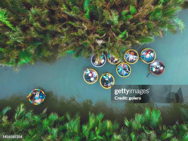 drohnenansicht auf bunten rundbooten auf der lagune in hoi an, vietnam - vietnam war stock-fotos und bilder