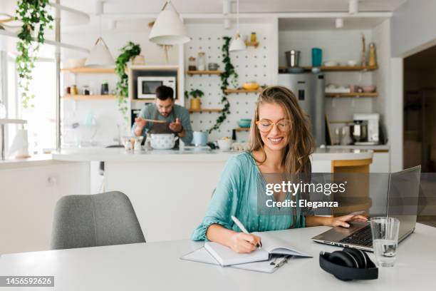 freund kocht, während seine freundin zu hause arbeitet - ehefrau stock-fotos und bilder
