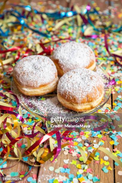 gebackene krapfen krapfen zum fasching faschingsfeier mit luftschlangen und konfetti - carnivale stock-fotos und bilder